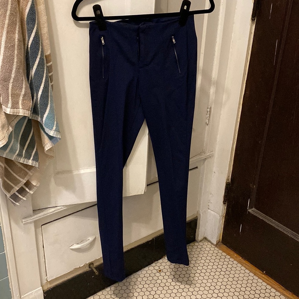 Navy skinny work pants with zipper detail.
